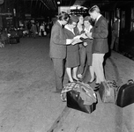 856578 Afbeelding van twee hostesses van de Zonexpres in gesprek met enkele reizigers op het eerste perron van het ...